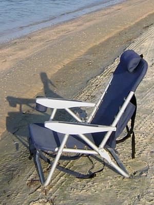 The folding camping chair at the beach rather than in the living room