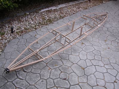 A small, wooden, foldable boat, fully assembled.